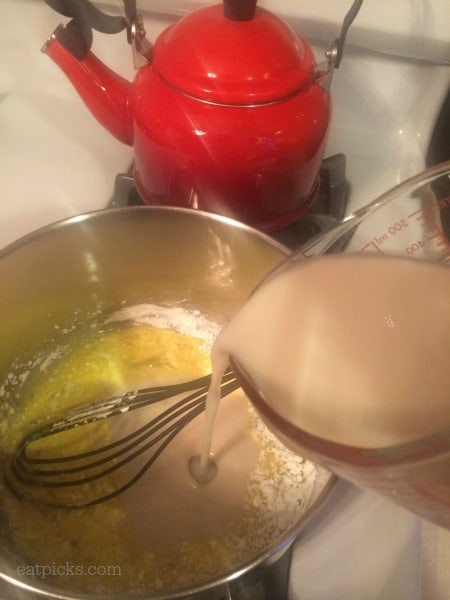 pouring cashew milk into saucepan