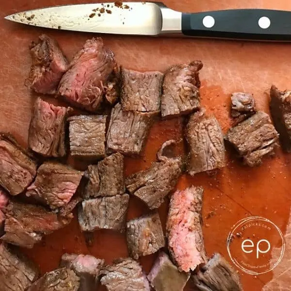 Steak slices on board with knife