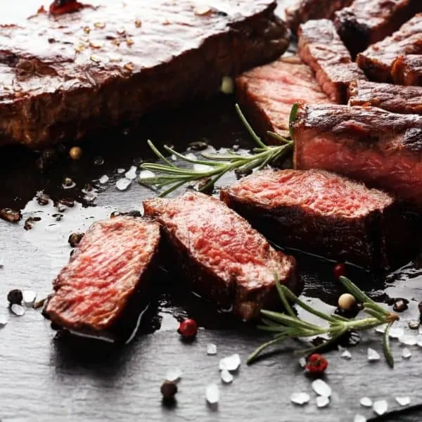 Steak slices on board with rosemary salt
