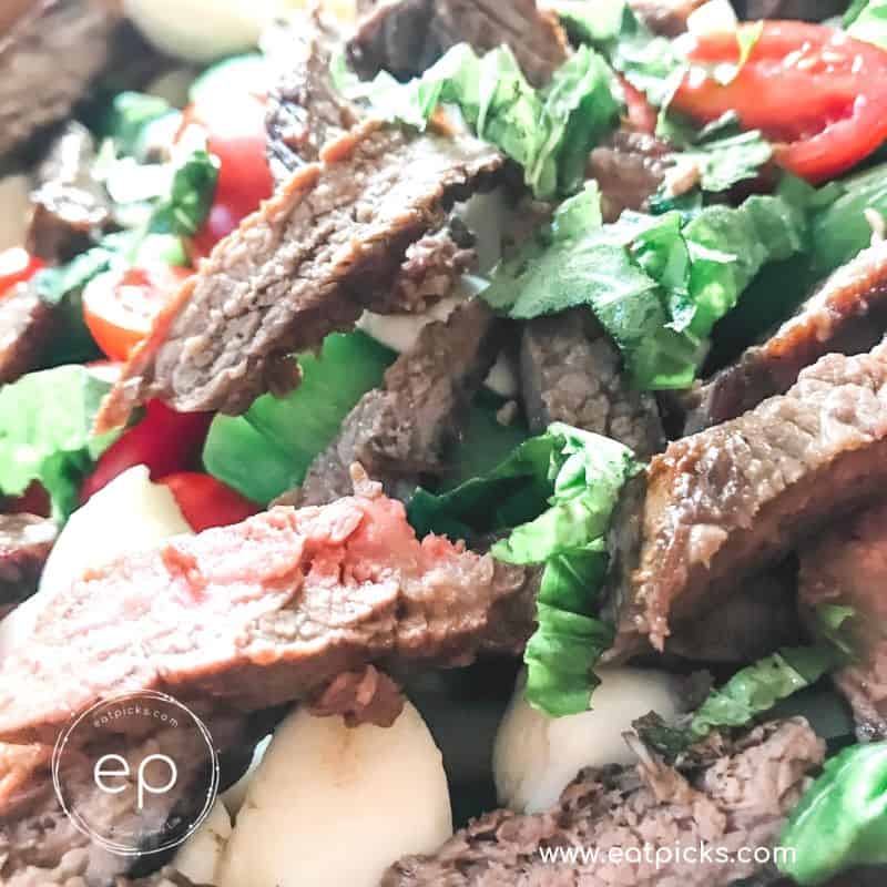 Juicy Sliced Sirloin Steak over pasta with fresh herbs and vegetables
