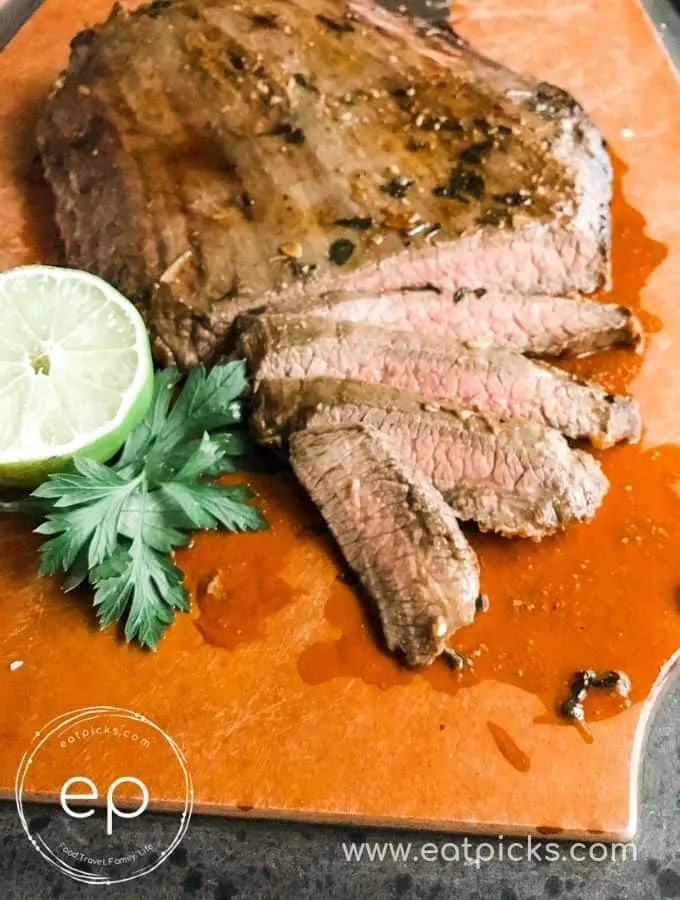 Sliced Cooked Garlic Lime Flank Steak on cutting board with