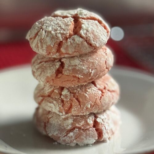 Strawberry Crinkle Cookies stacked on plate
